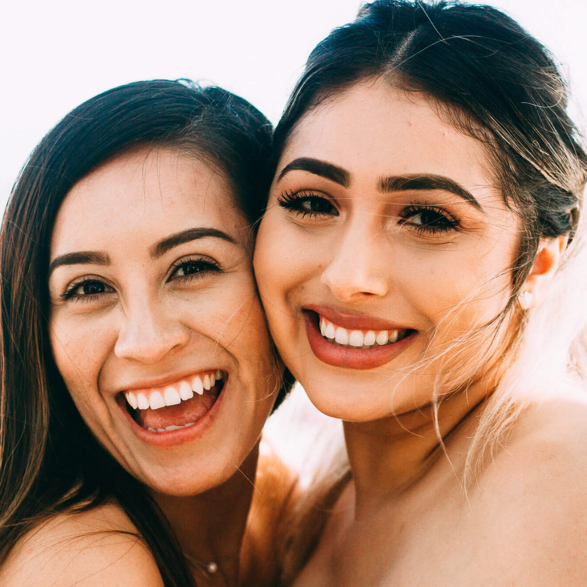 two women with bright white smiles